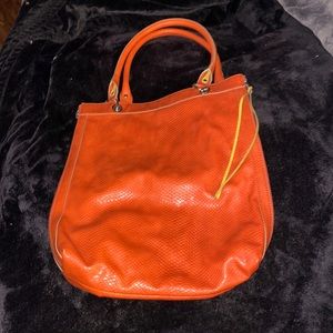 Orange leather Relic handbag. Zips on both outer sides. Small removable handbag
